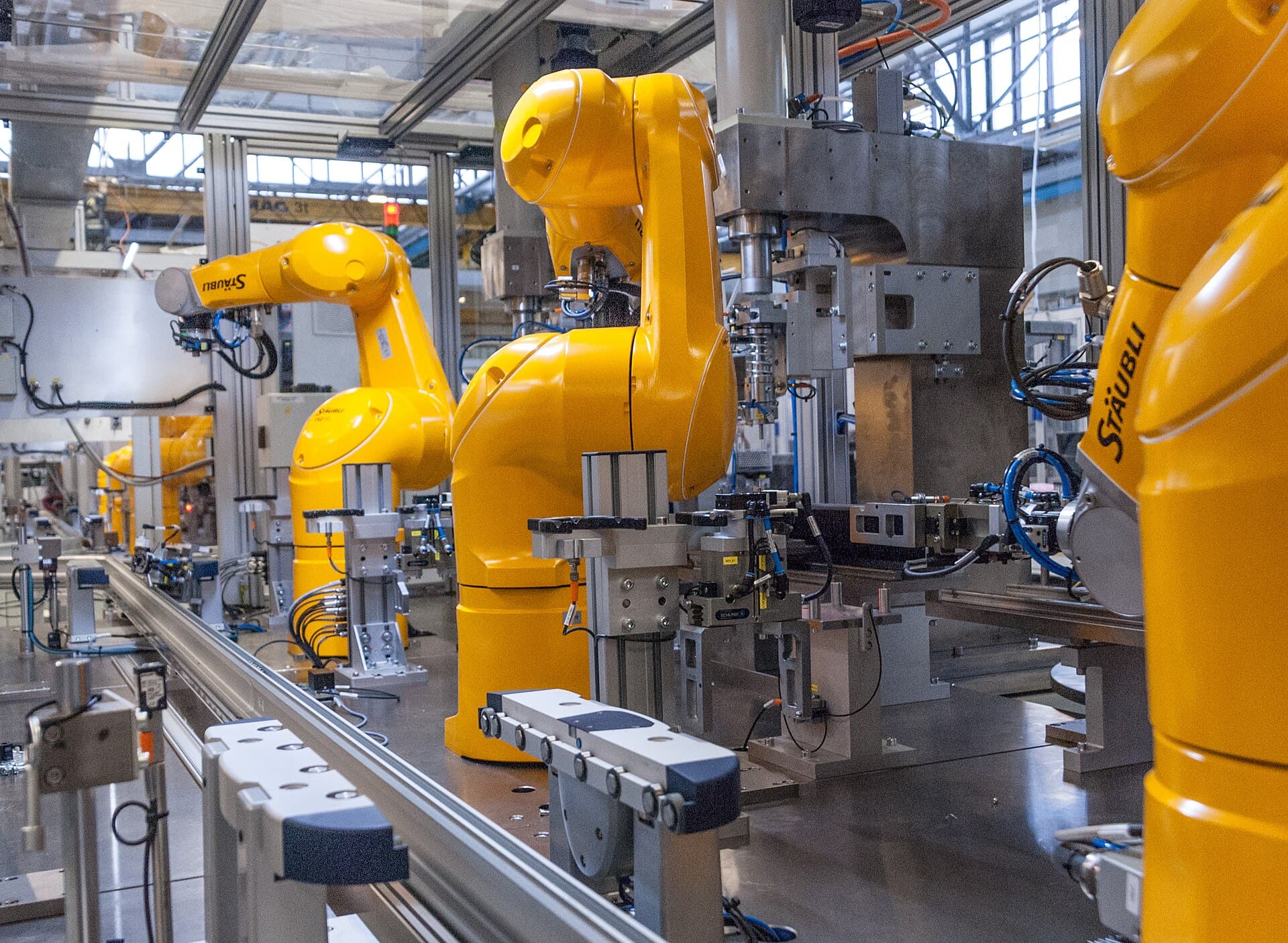 Lengan robot industri kuning pada lini manufaktur otomatis